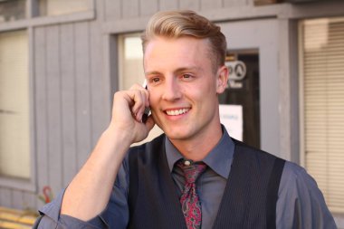 İngiliz centilmen güzellik konsepti. Dışarıda telefon kullanan genç ve yakışıklı bir adamın portresi. 