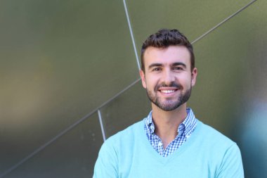 İşaretli gömlekli genç bir adam portresi ve kolları çapraz duran cyan süveter.