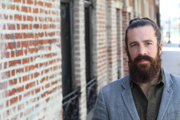 Tarz sahibi sakallı hippi modeli. Erkek saç stili, sokakta yaşam tarzı, tarlanın derinliği.