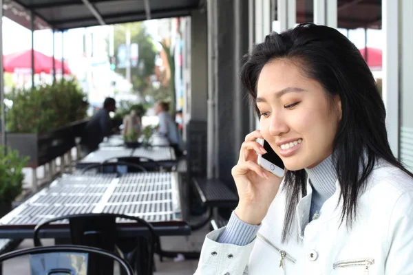 Asian woman using phone outdoor with copy space
