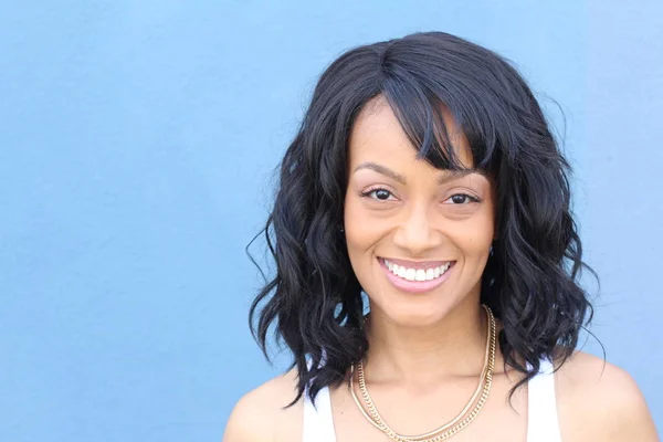 Closeup beauty portrait of a young and attractive African American black woman with perfect skin, softly smiling. Health and beauty outdoors lifestyle