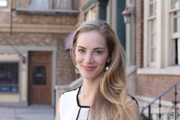 Portrait of naturally beautiful woman in her twenties with blond hair and blue eyes, shot outside in natural sunlight