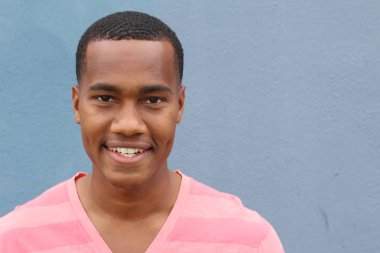 Yakışıklı, Afro-Amerikan, sıradan giyinmiş genç bir adamın yakın plan portresi.