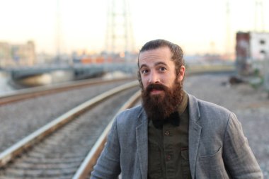 Tarz sahibi sakallı hippi modeli. Erkek saç stili, sokakta yaşam tarzı, tarlanın derinliği.