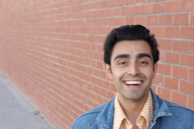 Kırmızı tuğla duvarın arka planında iyi bir adamın yakın plan portresi.