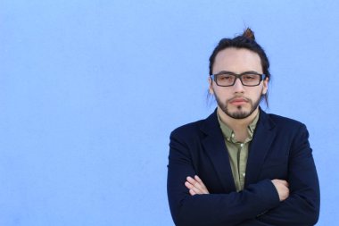 Mavi duvarın önünde uzun saçlı yakışıklı genç adamın yakın plan portresi.