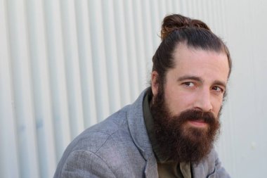 Tarz sahibi sakallı hippi modeli. Erkek saç stili, sokakta yaşam tarzı, tarlanın derinliği.