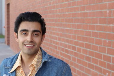 Kırmızı tuğla duvarın arka planında iyi bir adamın yakın plan portresi.