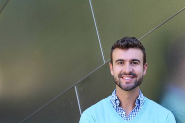 İşaretli gömlekli genç bir adam portresi ve kolları çapraz duran cyan süveter.