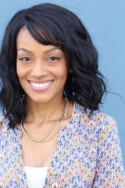 Closeup beauty portrait of a young and attractive African American black woman with perfect skin, softly smiling. Health and beauty outdoors lifestyle