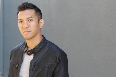 Karışık ırktan yakışıklı genç bir adamın yakın plan portresi. Sokakta günlük kıyafetlerle poz veriyor.