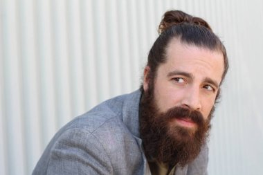 Tarz sahibi sakallı hippi modeli. Erkek saç stili, sokakta yaşam tarzı, tarlanın derinliği.