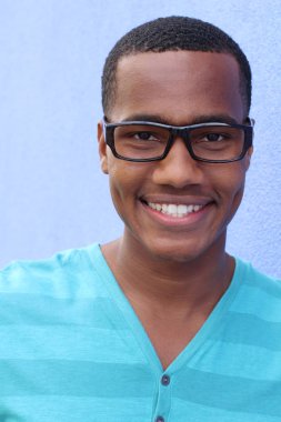 Yakışıklı, Afro-Amerikan, sıradan giyinmiş genç bir adamın yakın plan portresi.