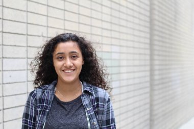 Şehirde gülümseyen genç bir kadının portresi.