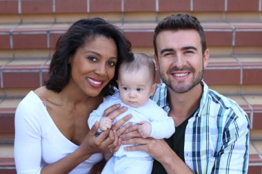 Yeni doğmuş bebeklerine sarılan ırklar arası bir çift.