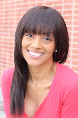 Closeup beauty portrait of young and attractive African American black woman with perfect skin, softly smiling. Health and beauty outdoors lifestyle