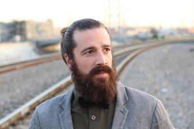 Tarz sahibi sakallı hippi modeli. Erkek saç stili, sokakta yaşam tarzı, tarlanın derinliği.