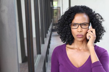 Şehirde akıllı telefonu olan çekici, olgun bir iş kadını.