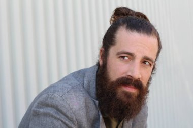 Tarz sahibi sakallı hippi modeli. Erkek saç stili, sokakta yaşam tarzı, tarlanın derinliği.