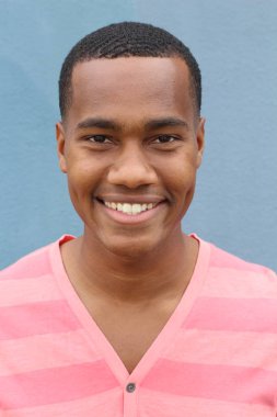 Yakışıklı, Afro-Amerikan, sıradan giyinmiş genç bir adamın yakın plan portresi.