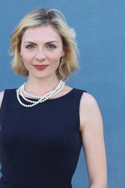 Şık, sarışın, sıradan saç stili ve akşam makyajlı bir kadının güzel portresi. İnci takan kadın