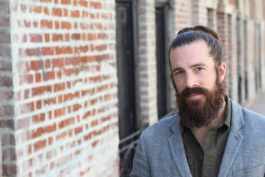 Tarz sahibi sakallı hippi modeli. Erkek saç stili, sokakta yaşam tarzı, tarlanın derinliği.