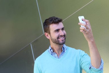 Kareli gömlekli genç bir adamın portresi ve telefonda konuşan Cyan süveteri. 