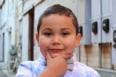 Açık havada, papyon takan şirin bir çocuğun portresi.