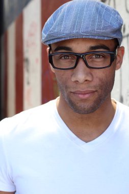 Yakışıklı, Afro-Amerikan bir adamın sokakta günlük kıyafetlerini çekerken yakın plan fotoğrafı.