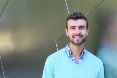 İşaretli gömlekli genç bir adam portresi ve kolları çapraz duran cyan süveter.