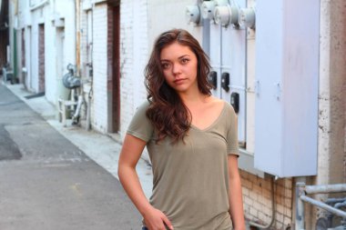 Açık havada duran melez üniversite öğrencisinin portresi.