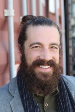 Tarz sahibi sakallı hippi modeli. Erkek saç stili, sokakta yaşam tarzı, tarlanın derinliği.