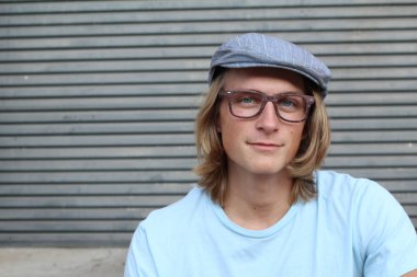 Sokakta uzun saçlı yakışıklı ve şık bir adamın yakın plan portresi.