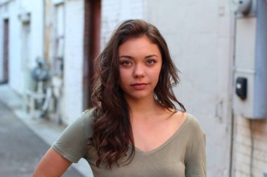 Açık havada duran melez üniversite öğrencisinin portresi.