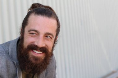 Tarz sahibi sakallı hippi modeli. Erkek saç stili, sokakta yaşam tarzı, tarlanın derinliği.