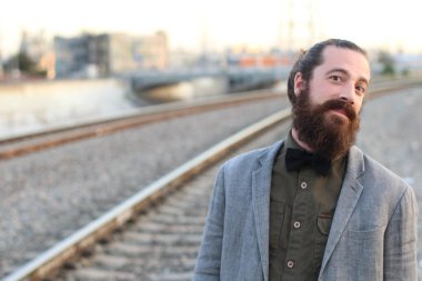 Tarz sahibi sakallı hippi modeli. Erkek saç stili, sokakta yaşam tarzı, tarlanın derinliği.