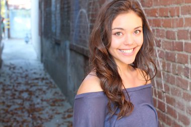 Açık havada duran melez üniversite öğrencisinin portresi.