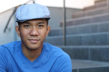 Karışık ırktan yakışıklı genç bir adamın yakın plan portresi. Sokakta günlük kıyafetlerle poz veriyor.