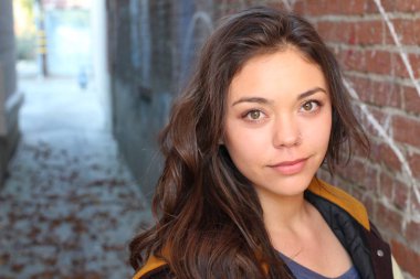 Açık havada duran melez üniversite öğrencisinin portresi.