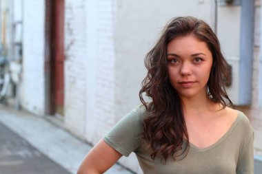 Açık havada duran melez üniversite öğrencisinin portresi.