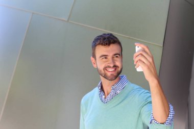 Kareli gömlekli genç bir adamın portresi ve telefonda konuşan Cyan süveteri. 