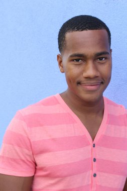 Yakışıklı, Afro-Amerikan, sıradan giyinmiş genç bir adamın yakın plan portresi.