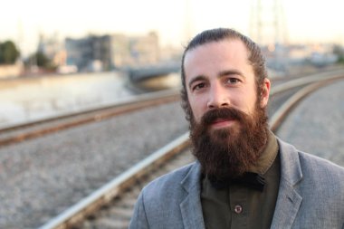 Tarz sahibi sakallı hippi modeli. Erkek saç stili, sokakta yaşam tarzı, tarlanın derinliği.