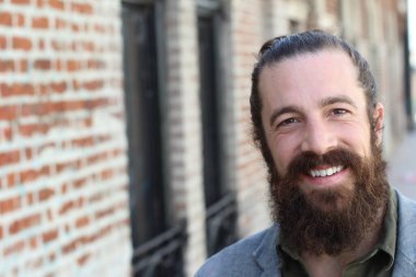 Tarz sahibi sakallı hippi modeli. Erkek saç stili, sokakta yaşam tarzı, tarlanın derinliği.