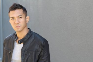 Karışık ırktan yakışıklı genç bir adamın yakın plan portresi. Sokakta günlük kıyafetlerle poz veriyor.