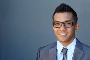Portrait of young Asian man with glasses in office smiling