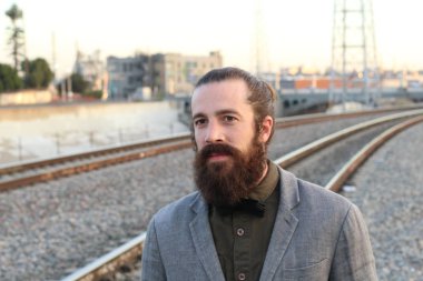 Tarz sahibi sakallı hippi modeli. Erkek saç stili, sokakta yaşam tarzı, tarlanın derinliği.