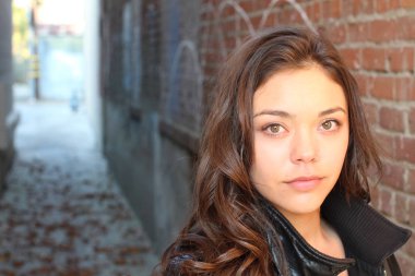 Açık havada duran melez üniversite öğrencisinin portresi.