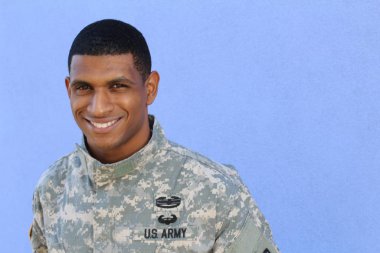 Mavi duvarın önünde üniformalı yakışıklı Afro-Amerikan askerinin yakın plan portresi