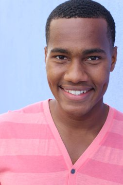 Yakışıklı, Afro-Amerikan, sıradan giyinmiş genç bir adamın yakın plan portresi.